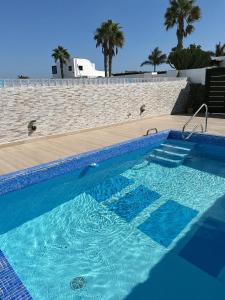 a swimming pool with blue water in front of a wall at Villa Lele in Playa Blanca