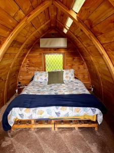 a bed in a room in a wooden cabin at Tui Ridge Eco Cabins in Aongatete