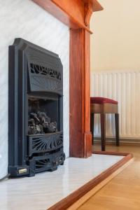 ロンドンにあるCozy 4-Bed House in Wimbledonの暖炉(テレビ付)