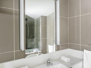 a bathroom with a sink and a mirror at Mantra Collins Hotel in Hobart +48 photos
