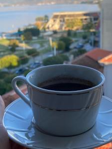 a cup of coffee on a plate with a window at One Bedroom Apartment Lake View Pogradec in Pogradec