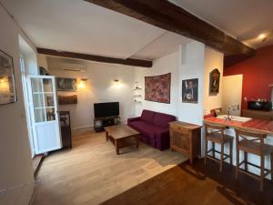 un salon avec un canapé violet et une table dans l'établissement Cyril - Appartement Pontet climatisé, à Avignon