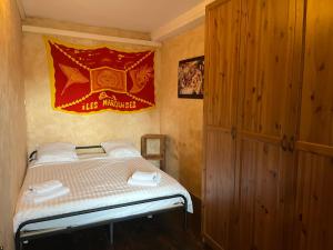 une petite chambre avec un lit et un drapeau rouge dans l'établissement Cyril - Appartement Pontet climatisé, à Avignon