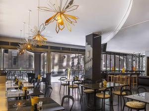 a restaurant with tables and chairs in a room at Mantra on Little Bourke Melbourne in Melbourne