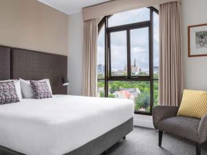 ein Hotelzimmer mit einem großen Bett und einem Fenster in der Unterkunft Mantra on Jolimont Melbourne in Melbourne + 64 Fotos