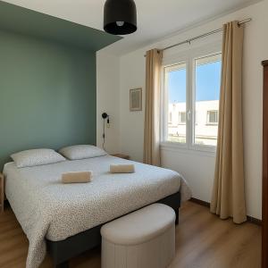 a bedroom with a bed and a large window at Les Sables de Palavas - T2 à 50m de la plage - clim, wifi in Palavas-les-Flots