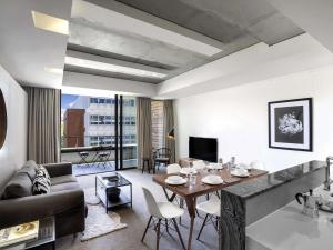 a living room with a table and a couch at Peppers Gallery Hotel in Canberra