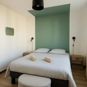 a bedroom with a bed with two towels on it at Les Sables de Palavas - T2 à 50m de la plage - clim, wifi in Palavas-les-Flots