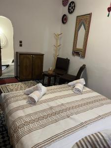 een slaapkamer met twee bedden en een spiegel aan de muur bij Fes Dar Riad - Stay Timeless in Fès
