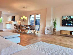 a living room with a table and a dining room at Modernes Haus in der Nähe des Flüghafens mit WLAN,Parkplatz,Terrasse in Egelsbach