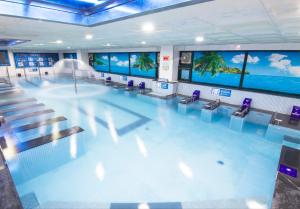 a large swimming pool with chairs and a swimming pool at Benikea Hotel Cheong Do Hot Spring in Cheongdo