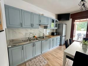 a kitchen with blue cabinets and a sink and a table at Appartamento Da Deki con ampio terrazzo vista Monte Grappa in Liedolo