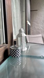 a glass table with a perfume bottle on top of it at Lindenhof Apartment 13 in Bad Aibling