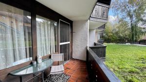 a balcony of a house with a glass table and chairs at Lindenhof Apartment 13 in Bad Aibling