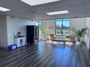 フローレンスにあるFlorence Inn and Suitesの椅子とテーブル、窓が備わる空き部屋