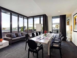 a living room with a long table and chairs at The Cullen Melbourne - Art Series in Melbourne