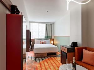 a hotel room with a bed and a couch at The Clarence Hotel Sydney in Sydney
