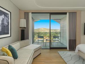 a living room with a couch and a view of a bedroom at Swissotel Resort And Spa Cesme in Çeşme