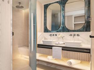 a bathroom with two sinks and a mirror at Swissotel Resort And Spa Cesme in Çeşme