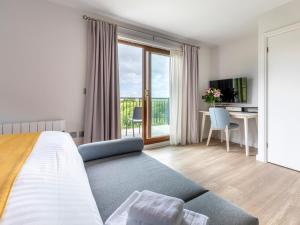 a bedroom with a bed and a desk and a window at 2 Bed in St. Mellion 87701 in St Mellion