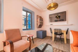 Una sala de estar con una silla y una mesa. en Dar Said, en Essaouira
