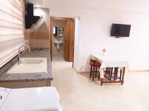 a kitchen with a sink and a table and a toilet at Reposant in Bin Rhilouf