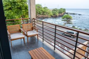 a balcony with two chairs and a view of the ocean at o som das ondas in Praia