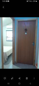 a wooden door in a room with a bed at Pousada Aconchego in Sidrolândia