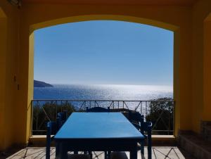 a table on a balcony with a view of the ocean at Villa Thea Kalymnos with swimming pool and sea view in Panormos Kalymnos