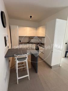 a kitchen with a counter and a white refrigerator at Il Nido UnaNotteaCasaMia in Cappuccini di Riano