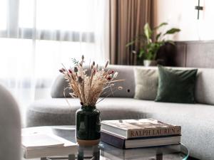 a vase with flowers on a table in a living room at Le Louise Hotel Brussels - MGallery Collection in Brussels