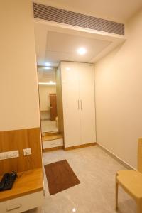 an empty room with a desk and a closet at The Royal Pavilion Hotel in Kanipakam +1 photo