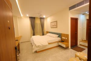 a small bedroom with a bed and a window at The Royal Pavilion Hotel in Kanipakam
