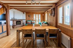 シャルドンヌにあるLe Chalet, Mont Pelerinの木製のテーブルと椅子のあるキッチンとリビングルーム
