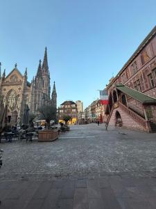 eine Stadtstraße mit einer Kathedrale im Hintergrund in der Unterkunft Studio dans le cœur de Mulhouse in Mulhouse
