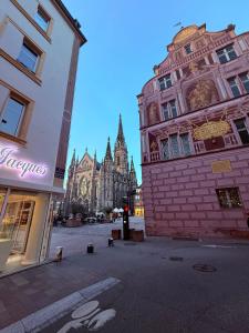 eine Stadtstraße mit Gebäuden und einer Kathedrale im Hintergrund in der Unterkunft Studio dans le cœur de Mulhouse in Mulhouse + 4 Fotos