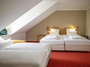 Duas camas num quarto com um sótão em Atomis Hotel Munich Airport by Mercure em Oberding