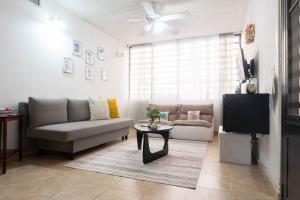 a living room with a couch and a tv at BeachBums Hideaway in Luquillo