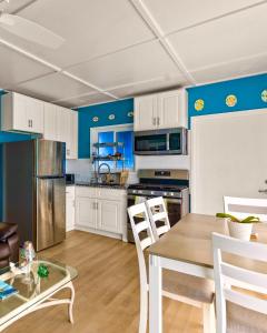 a kitchen with white cabinets and a table and chairs at Atlantic Blue Cottages # 1 in Scrub Hill
