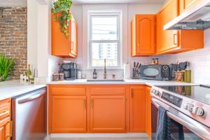 a kitchen with orange cabinets and a window at Prime Location Top Rated Clean Parking Free! in Columbus