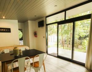 a living room with a table and chairs and a sliding glass door at Vida en el bosque in Necochea