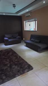 ein Wohnzimmer mit 2 Sofas und einem Teppich in der Unterkunft Chacara vale do igapó bauru in Bauru