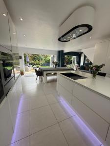 a large kitchen with white counters and a table at Portishead Coastal Retreat in Portishead