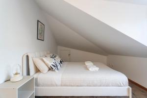 1 dormitorio con 1 cama blanca en el ático en Casa dos Barrett, en Lisboa