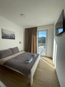 a bedroom with a large bed and a large window at Green panorama Vrdnik in Vrdnik +53 photos