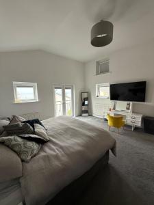 a bedroom with a large bed and a flat screen tv at Portishead Coastal Retreat in Portishead