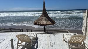 Dos sillas y una sombrilla en una mesa cerca del océano. en La costa, en Aguas Dulces 8 fotos más