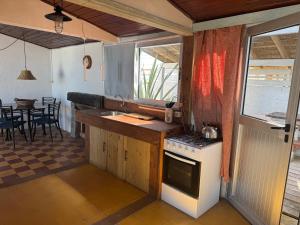 cocina con fogones, fregadero y mesa en La costa, en Aguas Dulces