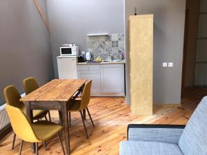 a kitchen with a wooden table and chairs in a room at Krāģīši - Quiet Countryside aura in Rencēni +5 photos