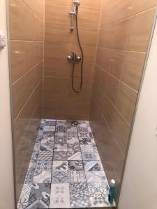 a bathroom with a shower with a tile floor at Krāģīši - Quiet Countryside aura in Rencēni